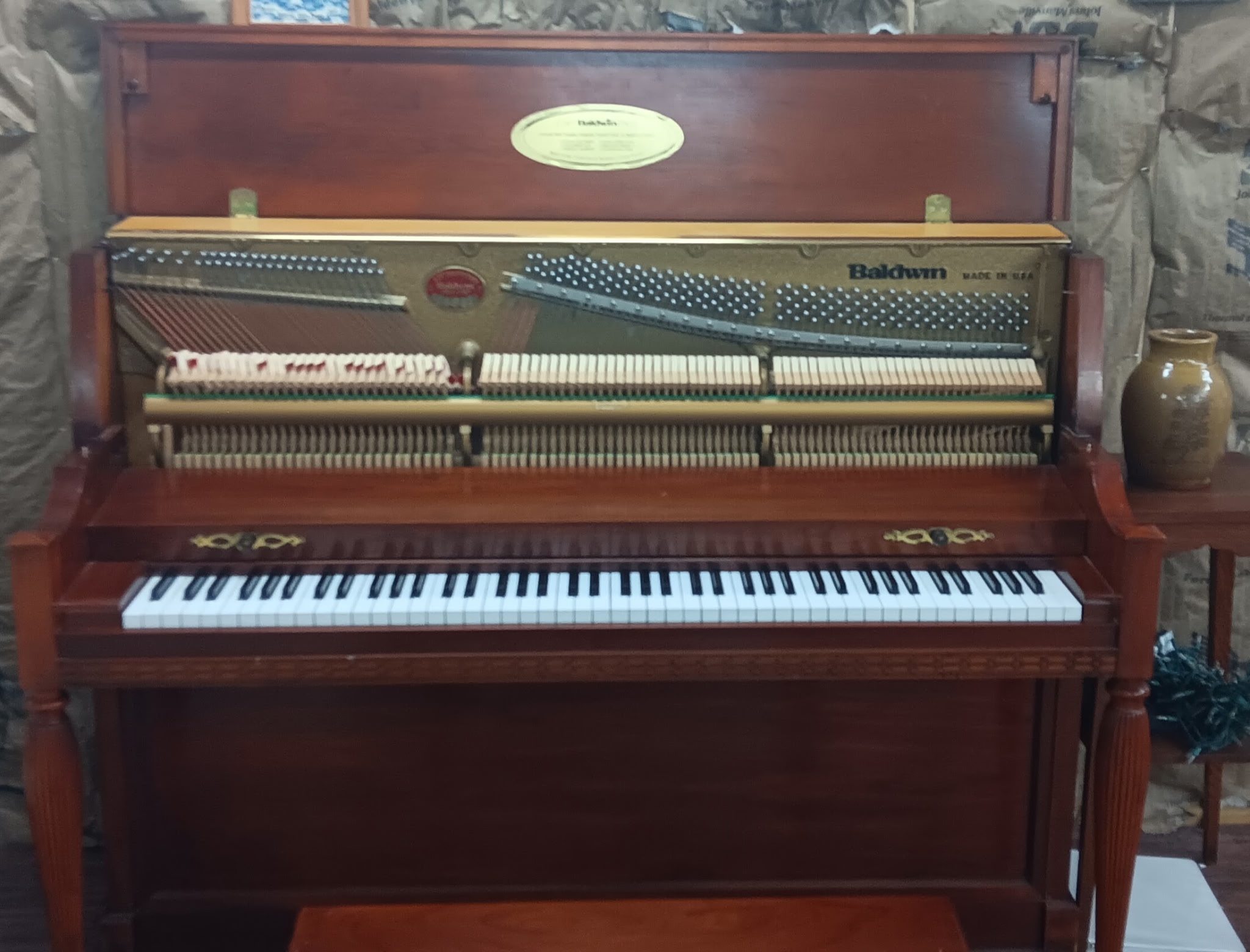 An old Baldwin studio piano with its action exposed during hammer replacement